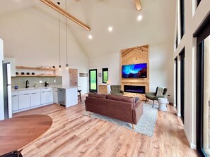 A modern kitchen with white cabinets, a built-in island, and pendant lighting.