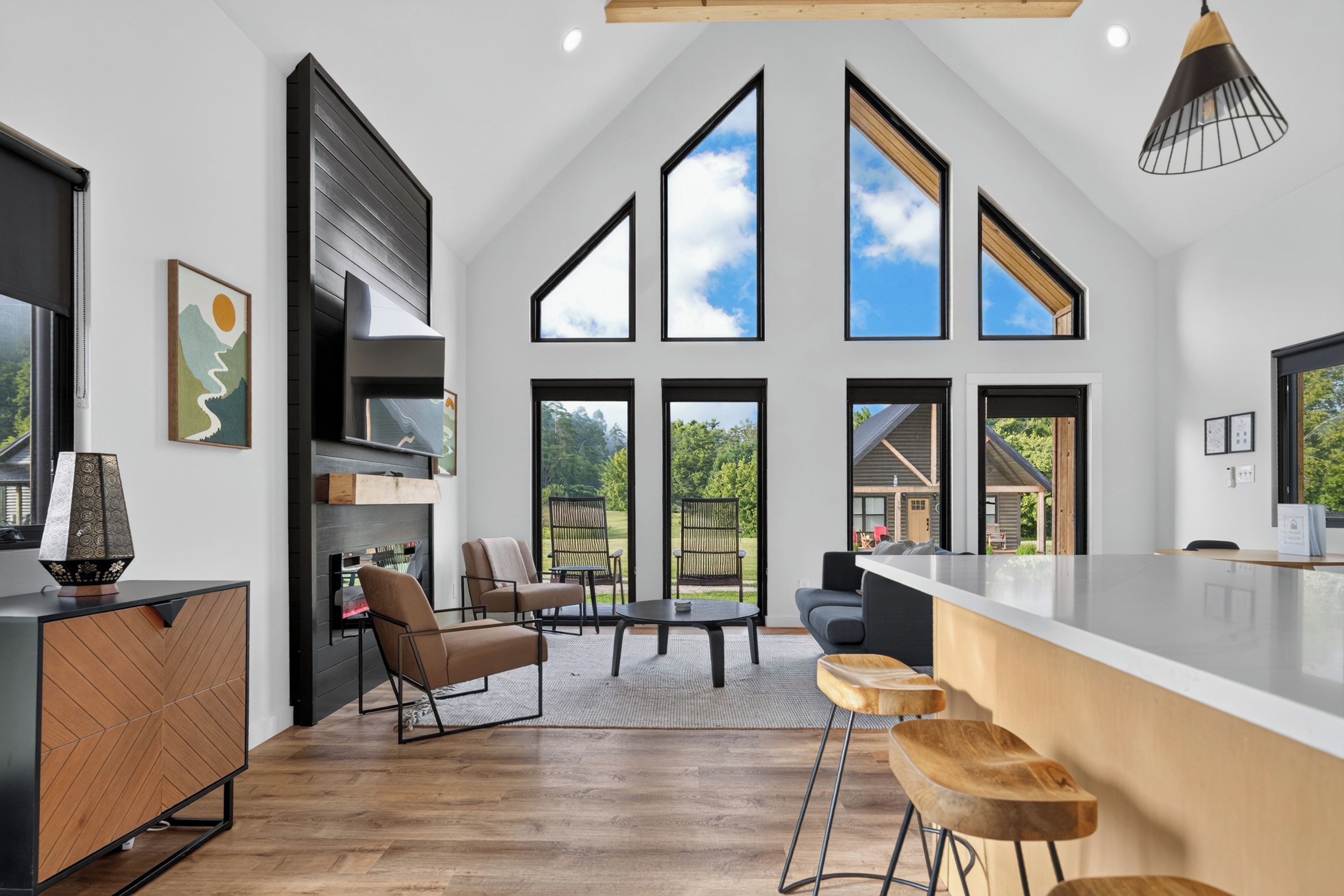 Een moderne keuken met een groot eiland, barkrukken en een eethoek met stoelen.