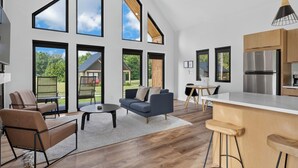 Une cuisine moderne dotée d’un grand îlot central, de meubles en bois et d’un réfrigérateur en acier inoxydable.