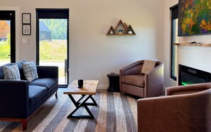 A living room with a sofa, armchair, coffee table, and a fireplace.