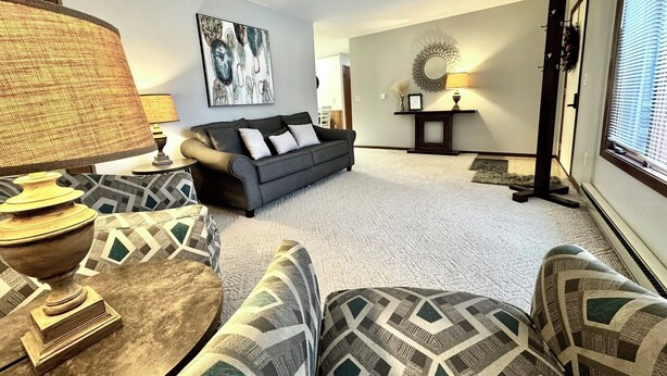 A living room with a sofa, patterned armchairs, a coffee table, a lamp, and artwork on the walls. - 3-bedroom house in delightful Mapleton with AC, WiFi. Unwind and enjoy! (Mapleton)