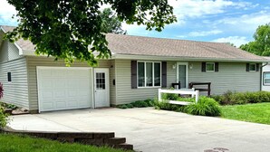 A single-story house with a garage, a front porch, and a small front yard. - 3-bedroom house in delightful Mapleton with AC, WiFi. Unwind and enjoy! (Mapleton)