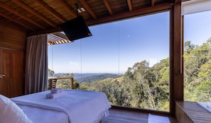 Un dormitorio con un ventanal que ofrece vistas a un paisaje montañoso.
