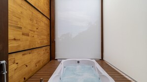 A small, private hot tub area with a wooden floor and a sliding door. - Cabana c\ lareira prox. de Florianópolis VST033 (Anitapolis)