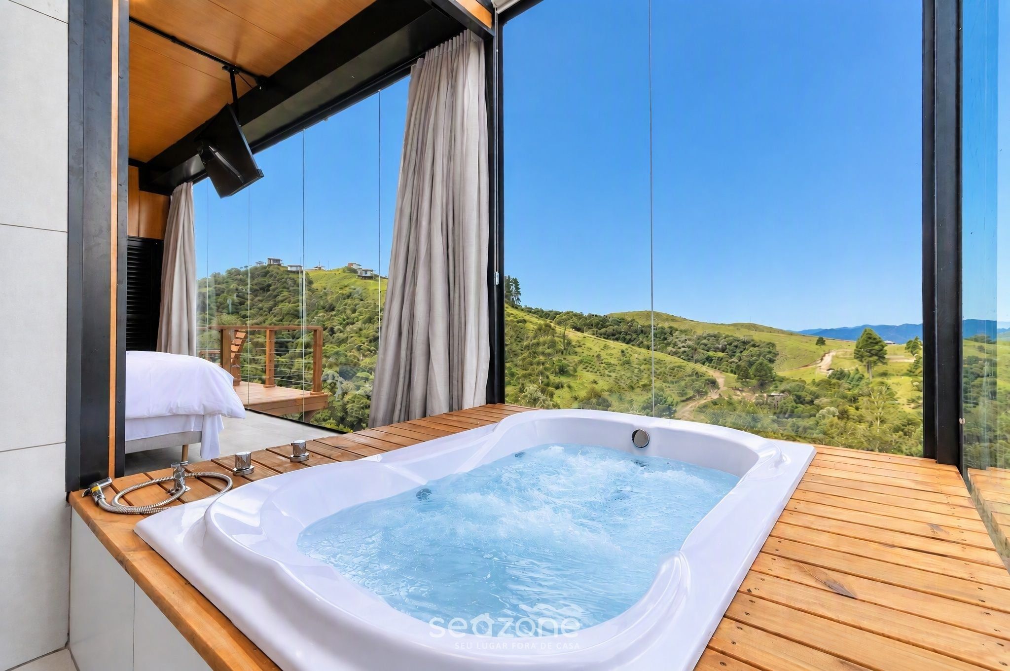 Un jacuzzi en una terraza de madera con vista a un paisaje montañoso.