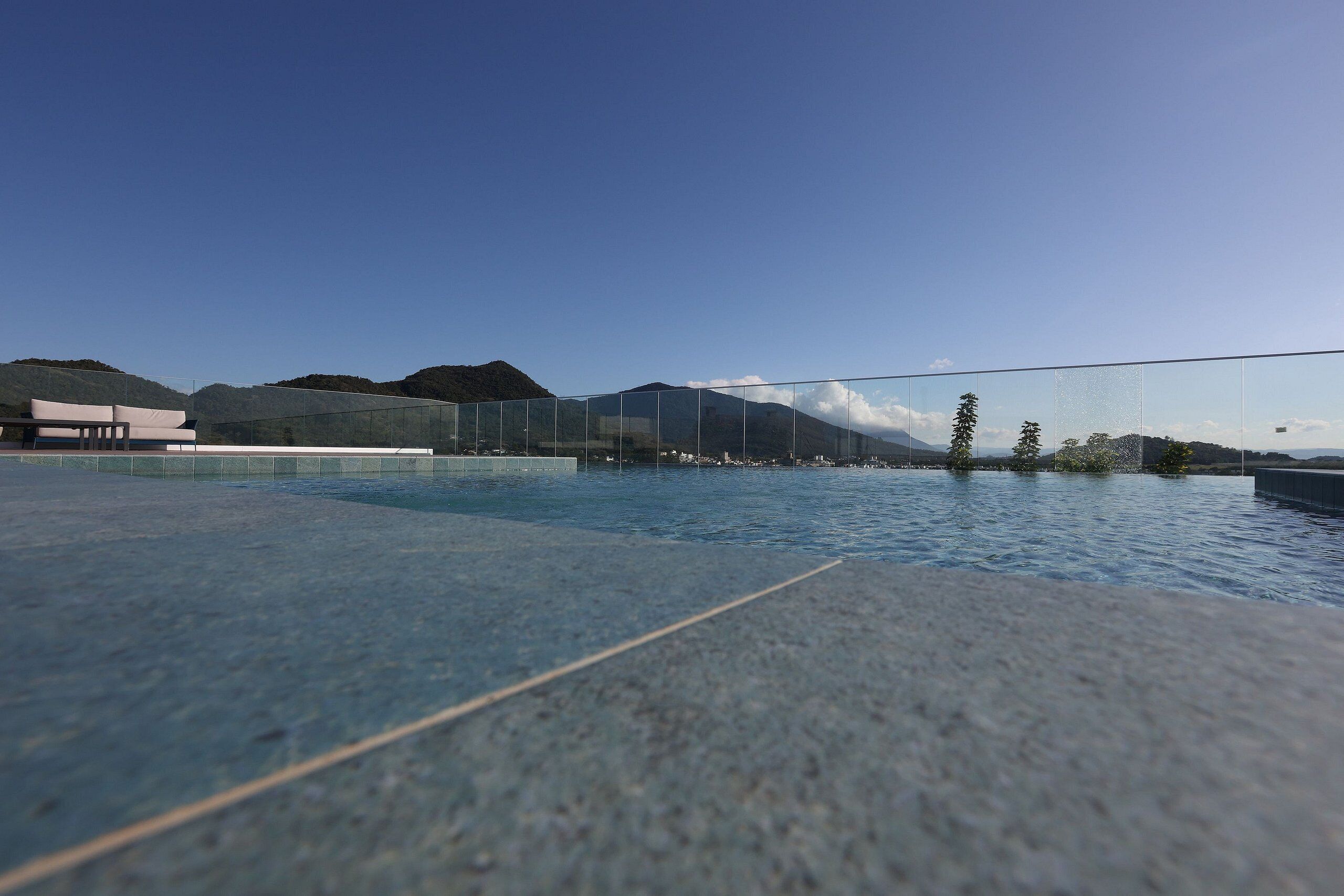 A modern outdoor pool area with a clear view of mountains in the background.
