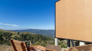 Una terraza de madera con vista a un paisaje montañoso.