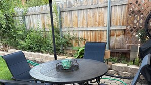 Eine Terrasse im Freien mit einem runden Tisch und vier Stühlen.