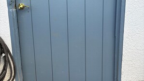 Eine blaue Tür mit einem Metallschild, auf dem "COTTAGE" steht.