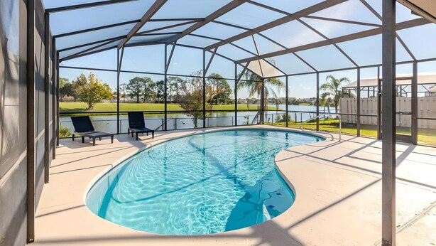 Una piscina techada con vistas despejadas a un lago y vegetación al fondo.