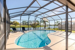Una piscina techada con vistas despejadas a un lago y vegetación al fondo.
