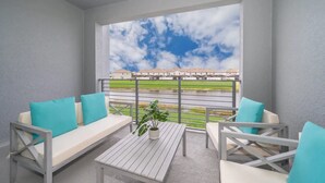 Un balcon donnant sur un quartier résidentiel et un plan d’eau.