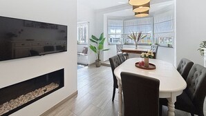 A modern dining area with a large table, chairs, and a hanging light fixture. - Maison 't Blyhuis - De Panne (De Panne)