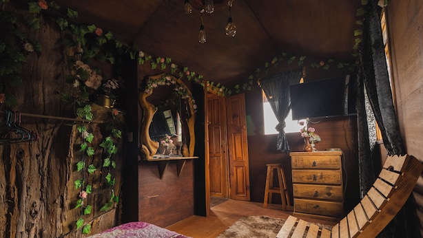 A rustic bedroom with a wooden bed, a wooden chair, a dresser, and a mirror. - Casita Del Arbol Trini By GEstores (Omitlán de Juárez)