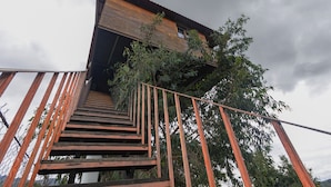 A wooden staircase leading to a building with a sloped roof and a window. - Casita Del Arbol Trini By GEstores (Omitlán de Juárez)