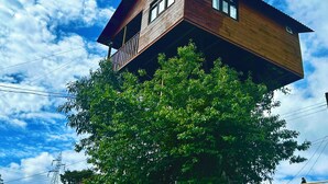 A two-story wooden house with a balcony, surrounded by lush green trees. - Casita Del Arbol Trini By GEstores (Omitlán de Juárez)
