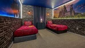 Een kamer met twee bedden, bakstenen muren en een muurschildering van een kasteel.