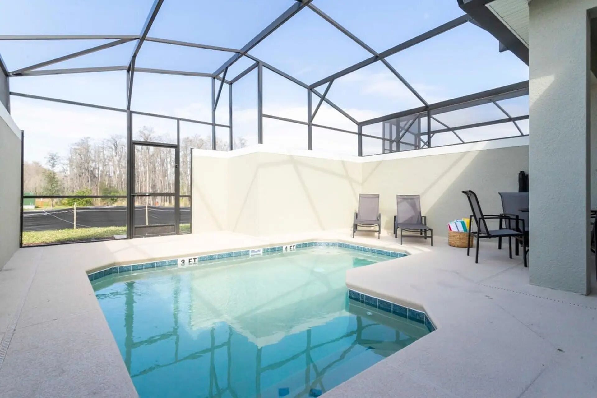 Une piscine intérieure dotée d’un toit en verre, entourée de chaises longues et d’une table.