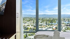 A bedroom with a large window offering a view of a cityscape and mountains. - Comfortable Standard Studio in Surfers Paradise (Surfers Paradise)