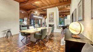 Comedor con mesa de madera, sillas y l ámpara de pie tipo globo.