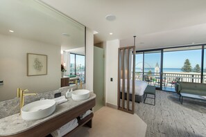 A modern bathroom with a large mirror, two sinks, and a view of the sea through large windows. - The George Glenelg (Adelaide)
