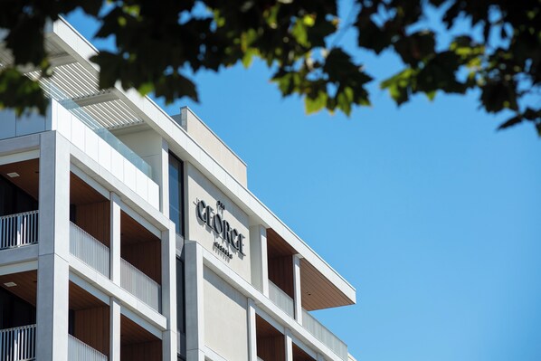 Ein mehrstöckiges Hotel mit modernem architektonischen Design, mit Balkonen und blauem Himmel im Hintergrund.