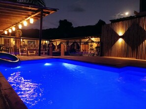 Una piscina al aire libre, sillones reclinables de piscina