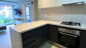 A modern kitchen with black and white cabinetry, a Bosch oven, and a built-in gas stove. - Coastal Blvd Apartment -Barranco (Lima)