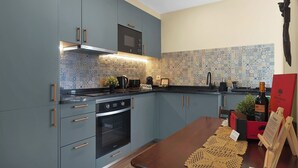 Una cucina moderna con mobili grigi, un forno nero e un backsplash decorato.