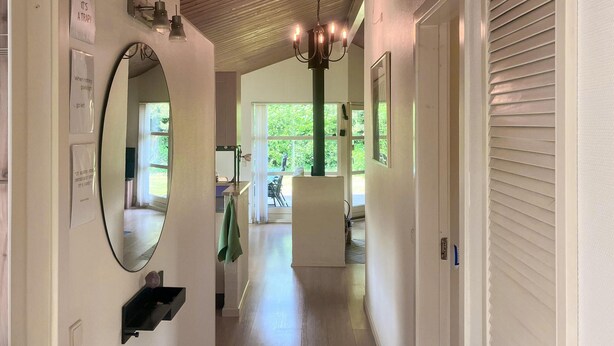 A hallway with a chandelier, a mirror, and a sign with motivational quotes. - Stunning home in Melby with WiFi (Melby)