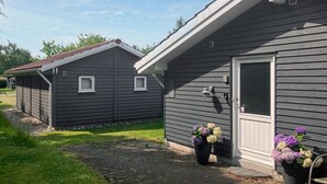 A two-story house with a grey exterior, a front door, and two small windows. - Stunning home in Melby with WiFi (Melby)