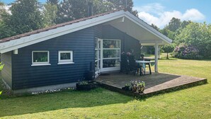 A single-story house with a covered porch, a small deck, and a garden area. - Stunning home in Melby with WiFi (Melby)
