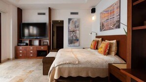 Een slaapkamer met een groot bed, een televisie en een kast.
