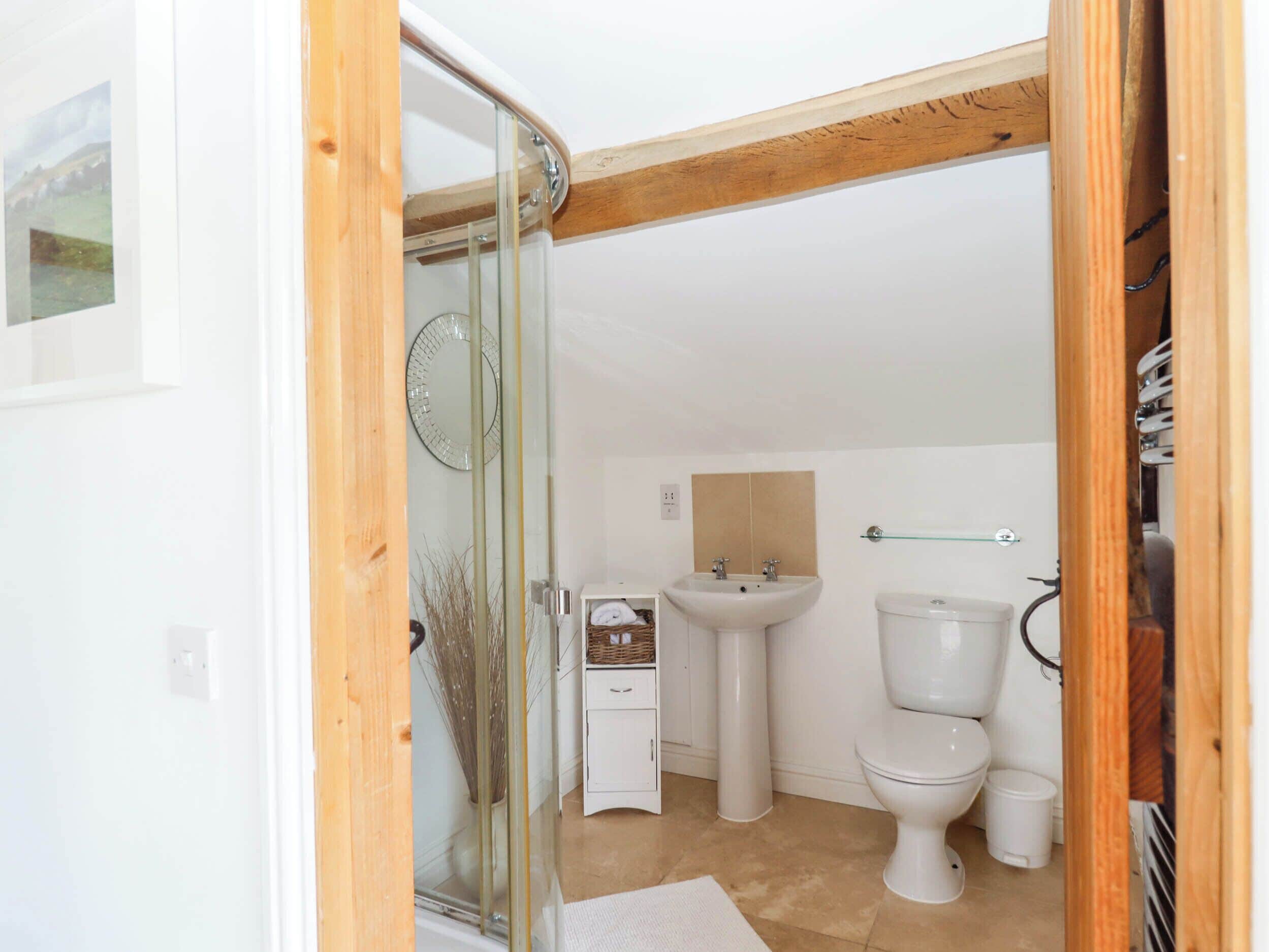 Une salle de bain avec une douche à parois de verre, un lavabo blanc et des toilettes.