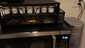 A coffee maker with a digital display, a microwave, and a Keurig coffee maker on a wooden surface. - Two bedroom  in United States of America, Jersey City (Jersey City)
