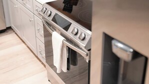 Cozinha moderna com eletrodomésticos de aço inoxidável, incluindo forno e micro-ondas.