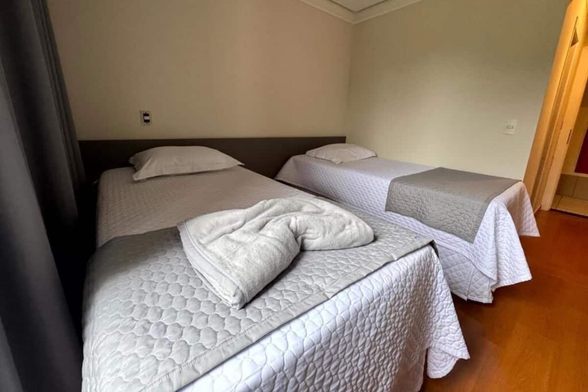 Une chambre d’hôtel avec deux lits, chacun doté d’un matelas et de coussins matelassés.
