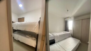Une chambre de dortoir avec des lits superposés, une fenêtre avec des rideaux et un appareil de climatisation.