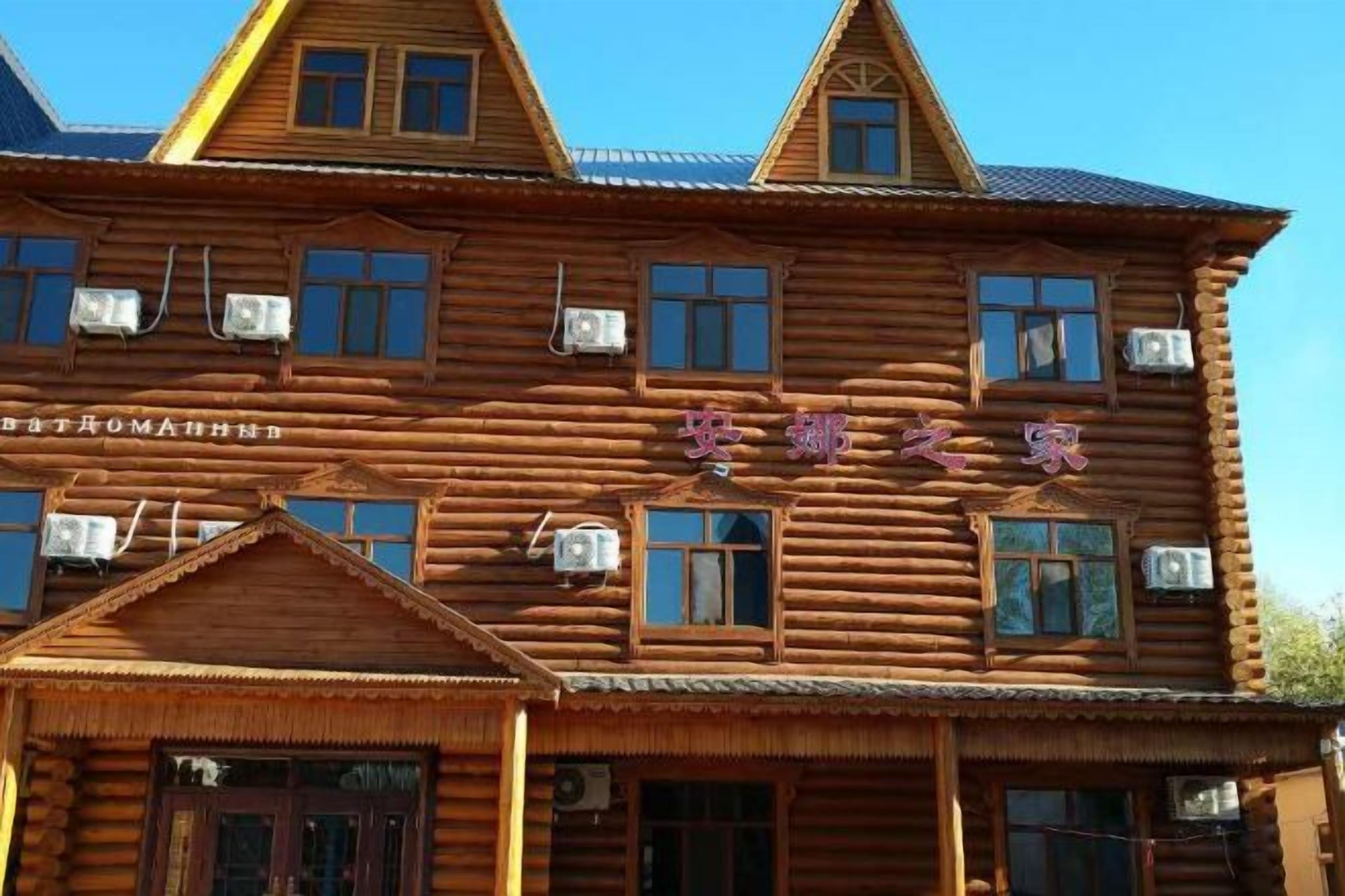 Un edificio de madera tradicional con varias ventanas y un letrero en un alfabeto extranjero.