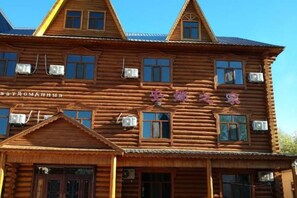 A traditional wooden building with multiple windows and a sign in a foreign script. - Ergun Shiwei Lanxin Dream Home (Ergun)
