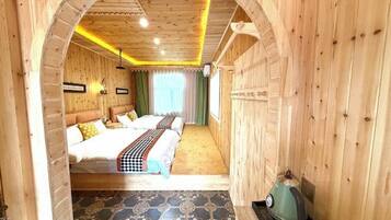 Una habitación de madera con una cama, una tetera y un suelo estampado.