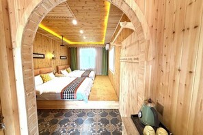 Una habitación de madera con una cama, una tetera y un suelo estampado.