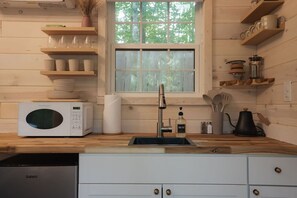 Fridge, microwave, coffee/tea maker, cookware/dishes/utensils