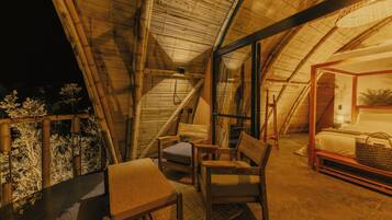 Une pièce confortable et bien éclairée, avec un lit, une chaise en bois et une table.