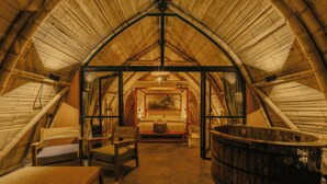 An attic room with a bed, seating area, and a hot tub. - Hotel Casa Selvaggio (Ráquira)