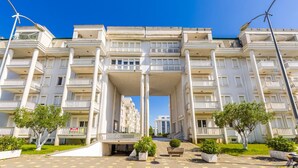 A multi-story residential building with balconies, a central entrance, and a paved driveway. - Velipoja Beach Apartment by PikHost (Velipojë)