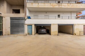 Un parking à plusieurs niveaux, avec une voiture garée à l’étage intermédiaire.