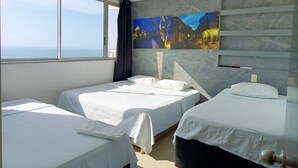 A hotel room with two beds, a large window with a view of the sea, and a wall-mounted painting. - 2 Bedroom Oceanfront Apartment with Restaurant (Cartagena de Indias)