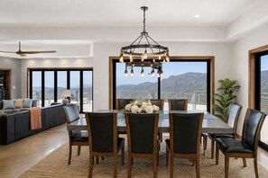 Un comedor con candelabro, un sofá y vistas a la montaña.