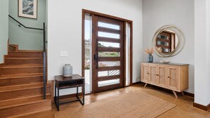 A wooden staircase leading to a door with a view of a landscape.